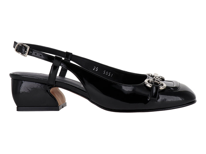 Zapato de tacón bajo en charol negro con hebilla plateada y correa posterior.