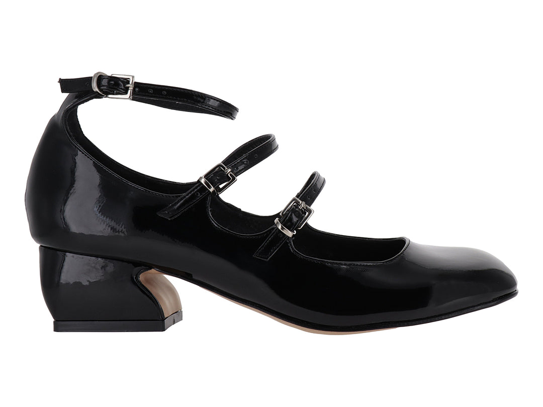 Zapato de tacón bajo en charol negro con tres correas ajustables y hebillas plateadas.