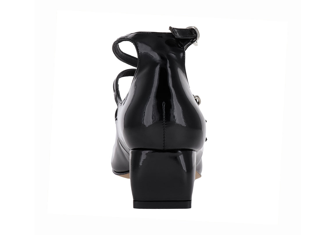 Zapato de tacón bajo en charol negro con tres correas ajustables y hebillas plateadas.