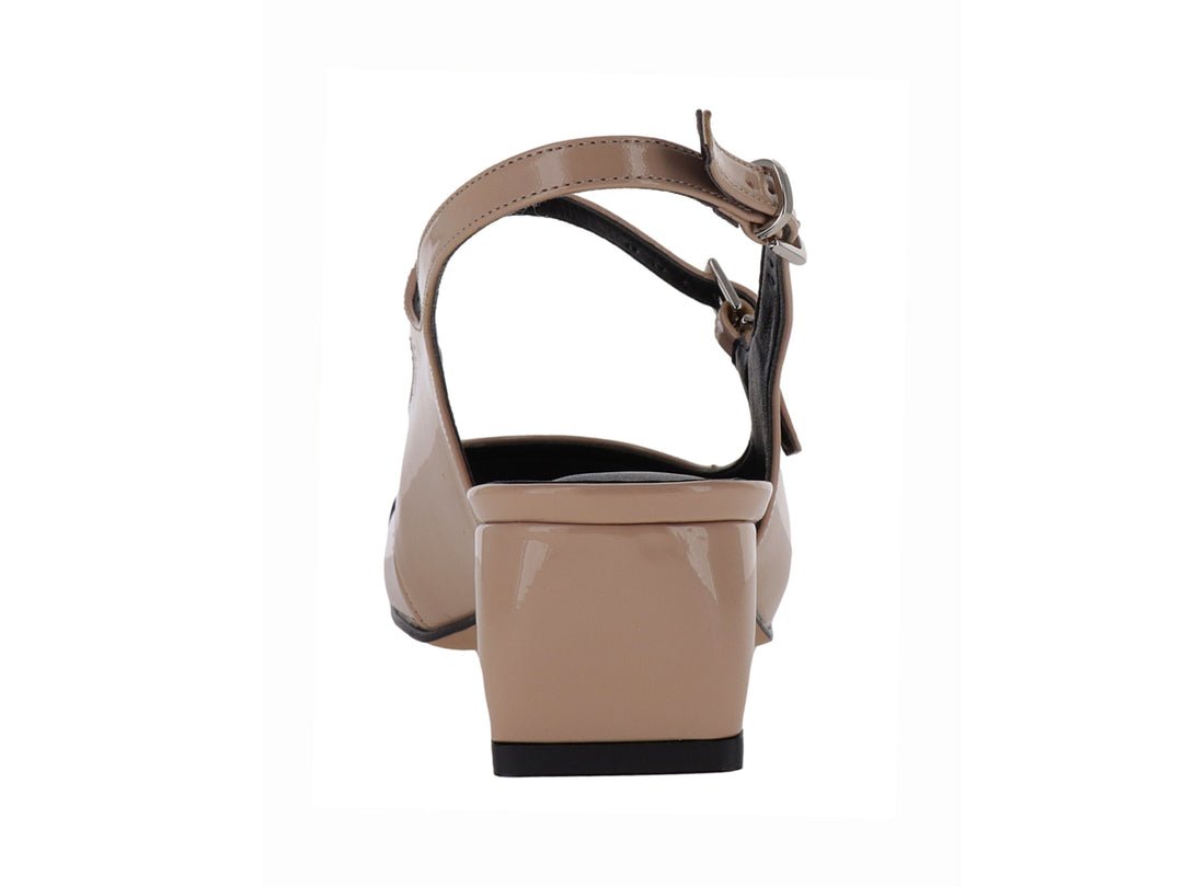 Zapato de tacón bajo en color nude con punta negra brillante y correa ajustable al tobillo.