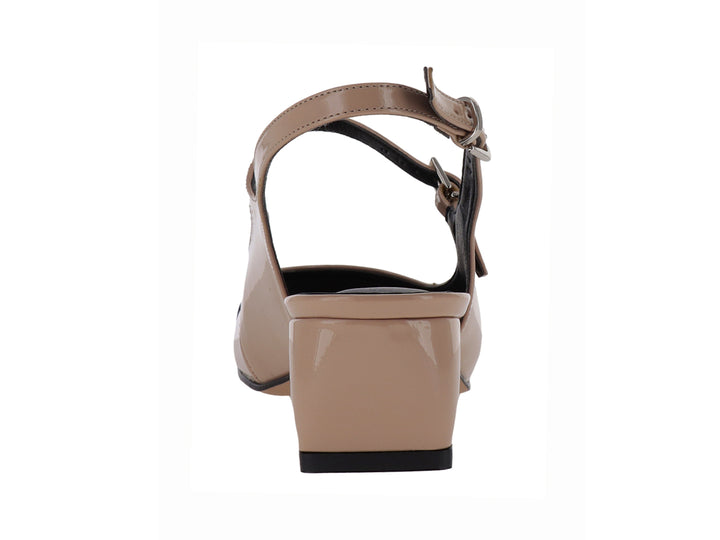 Zapato de tacón bajo en color nude con punta negra brillante y correa ajustable al tobillo.