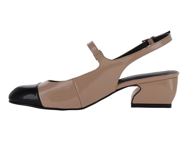 Zapato de tacón bajo en color nude con punta negra brillante y correa ajustable al tobillo.