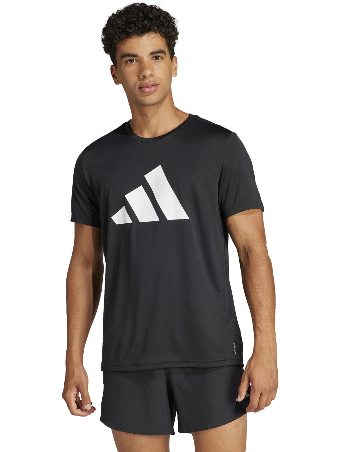 Hombre vistiendo camiseta deportiva negra de manga corta con logotipo blanco de Adidas en el pecho.