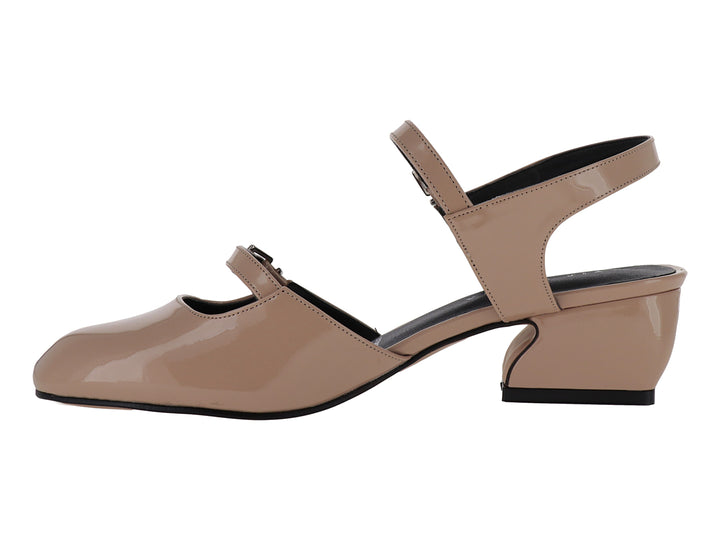 Zapato de charol sintético color nude con tacón bajo y correa ajustable al tobillo.