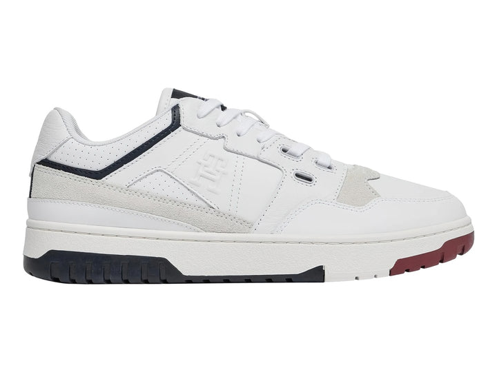Tenis blancos Tommy Hilfiger de corte bajo con detalles en azul marino y rojo en la suela.