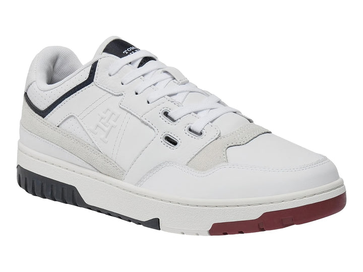 Tenis blancos Tommy Hilfiger de corte bajo con detalles en azul marino y rojo en la suela.