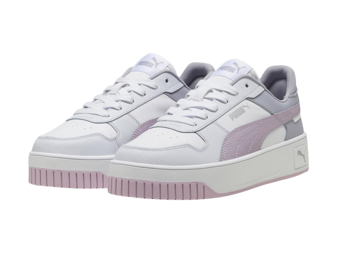 Tenis PUMA Carina Street blancos con detalles en morado y plateado y suela de plataforma blanca.