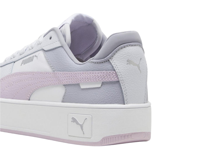 Tenis PUMA Carina Street blancos con detalles en morado y plateado y suela de plataforma blanca.