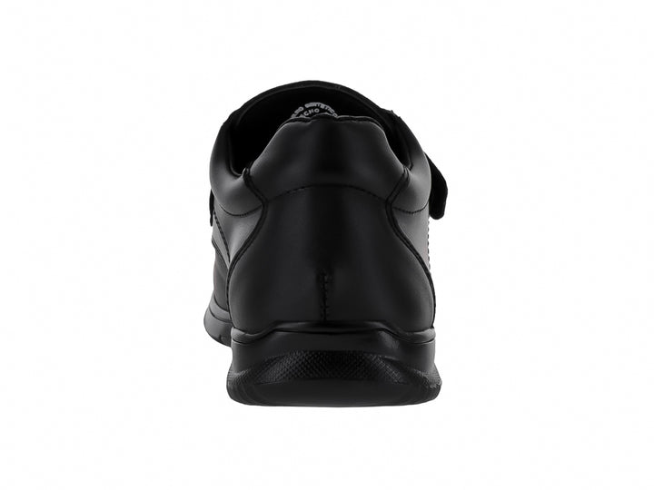 Zapato formal negro para niño con correa de velcro y suela negra.