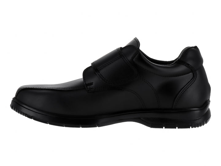Zapato formal negro para niño con correa de velcro y suela negra.