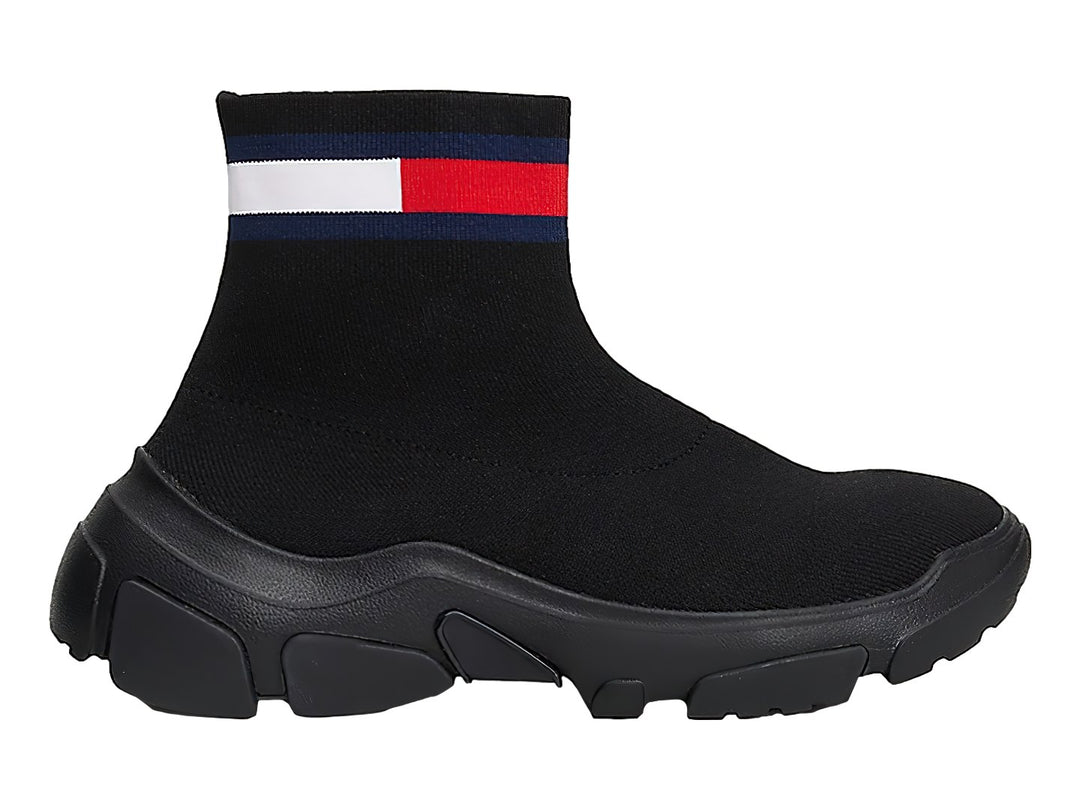 Tenis botín tipo calcetín color negro con suela gruesa y franja tricolor en el tobillo.