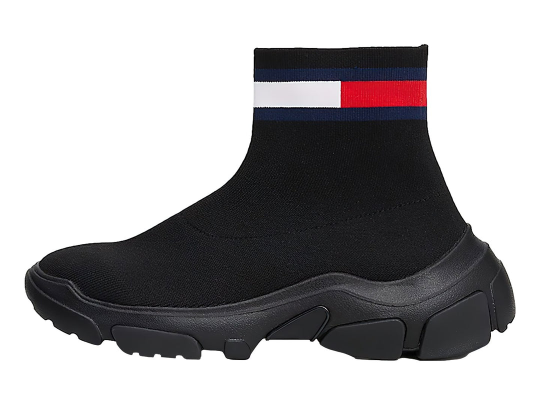 Tenis botín tipo calcetín color negro con suela gruesa y franja tricolor en el tobillo.
