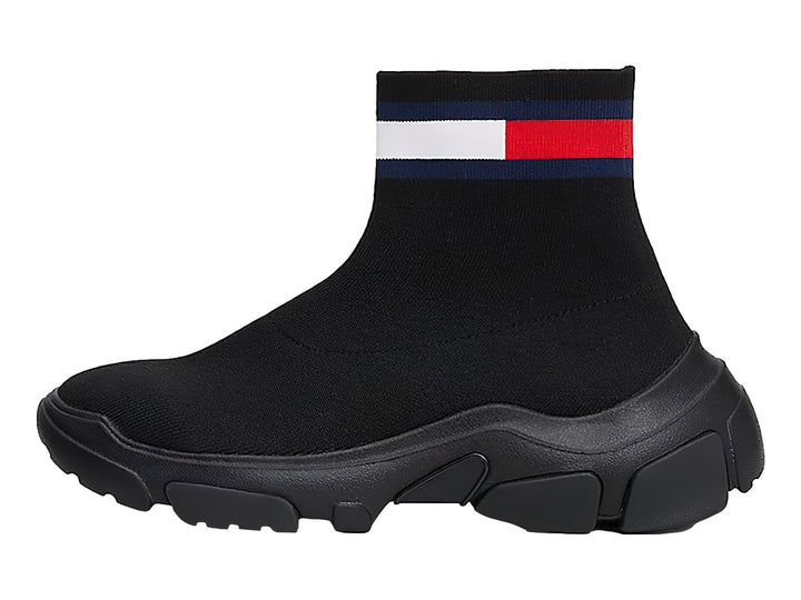 Tenis botín tipo calcetín color negro con suela gruesa y franja tricolor en el tobillo.