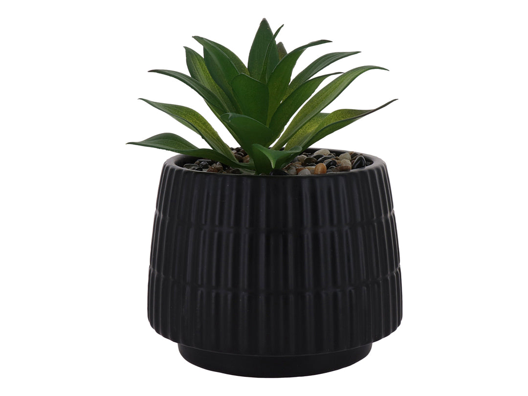 Planta artificial verde en maceta decorativa de dolomita color negro con textura acanalada.