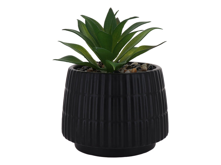 Planta artificial verde en maceta decorativa de dolomita color negro con textura acanalada.