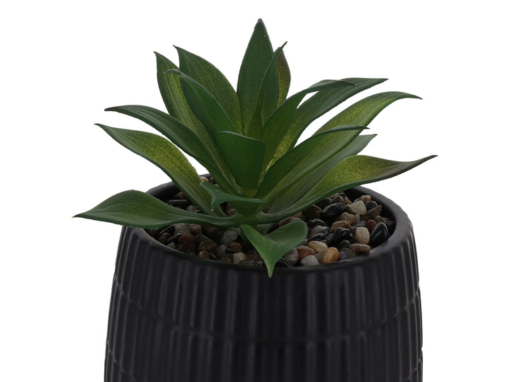 Planta artificial verde en maceta decorativa de dolomita color negro con textura acanalada.