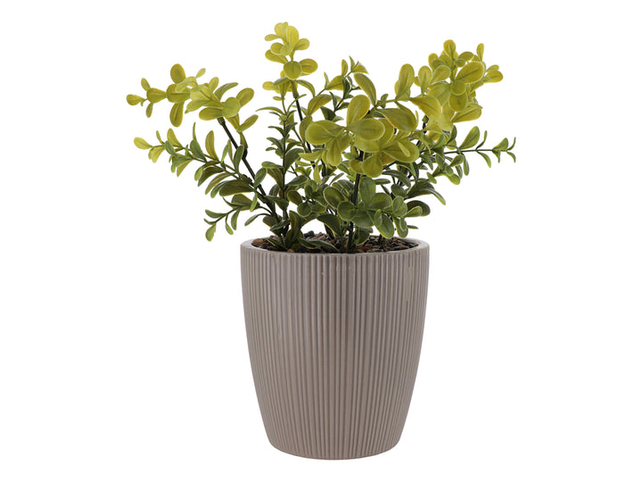 Planta artificial verde en maceta decorativa de dolomita color beige con textura acanalada.