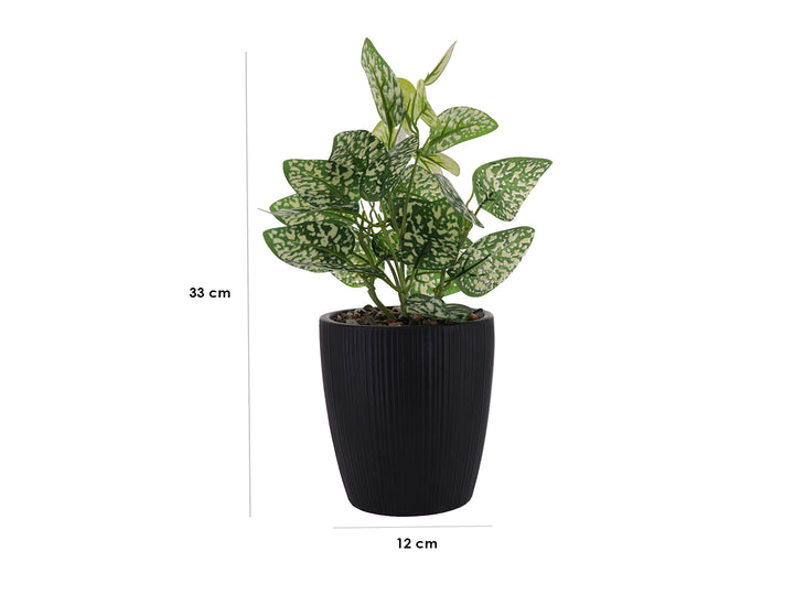 Planta artificial con hojas verdes y blancas en maceta decorativa de color negro acanalada.
