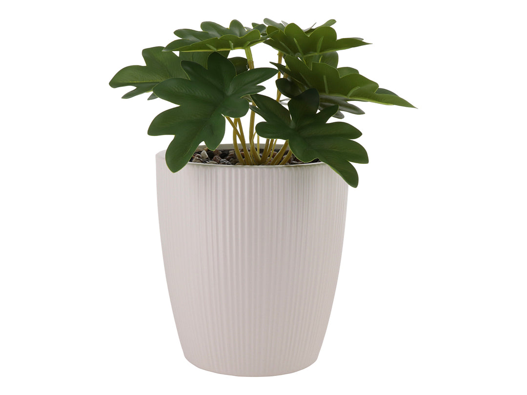 Planta artificial con hojas verdes en maceta de dolomita blanca acanalada.