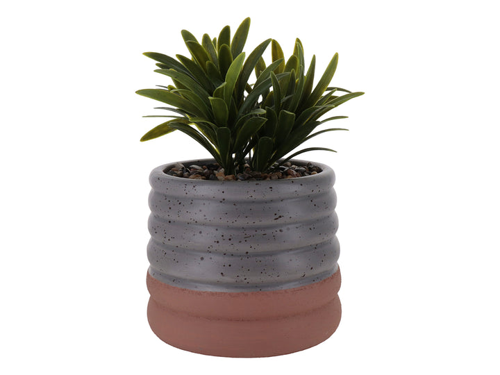 Planta artificial en maceta de cerámica gris con diseño ondulado y base color terracota.
