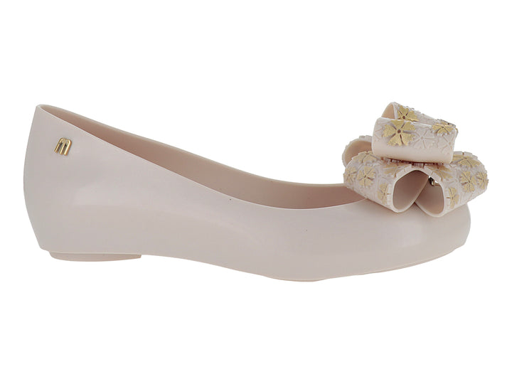 Zapato plano color rosa pálido con un moño decorativo en la punta.
