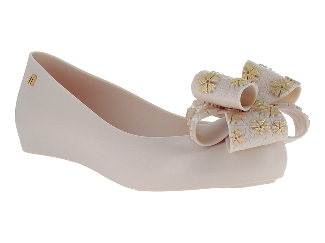 Zapato plano color rosa pálido con un moño decorativo en la punta.