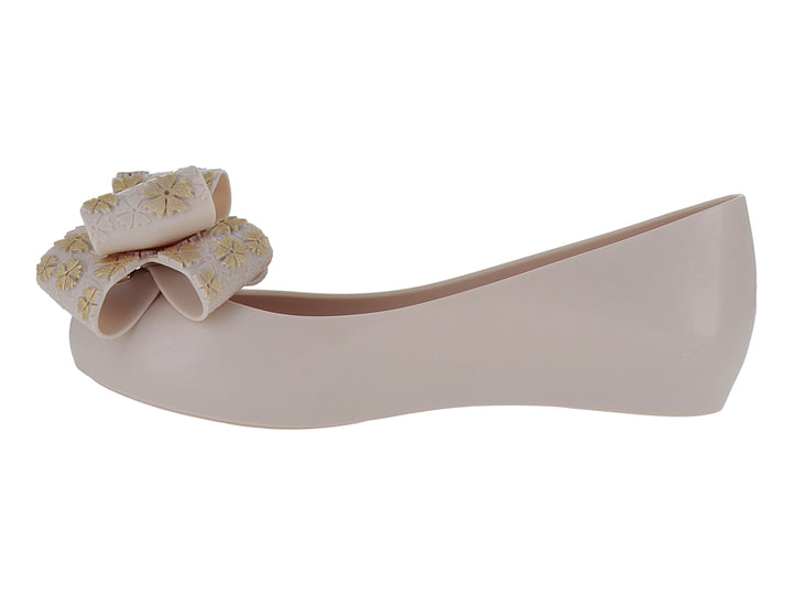 Zapato plano color rosa pálido con un moño decorativo en la punta.