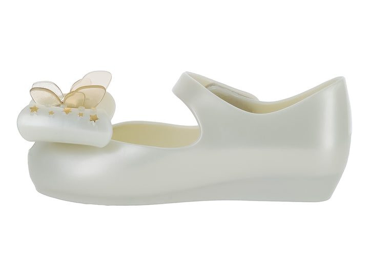 Zapato blanco brillante para niña de Mini Melissa con correa y adorno de moño con estrellas doradas.
