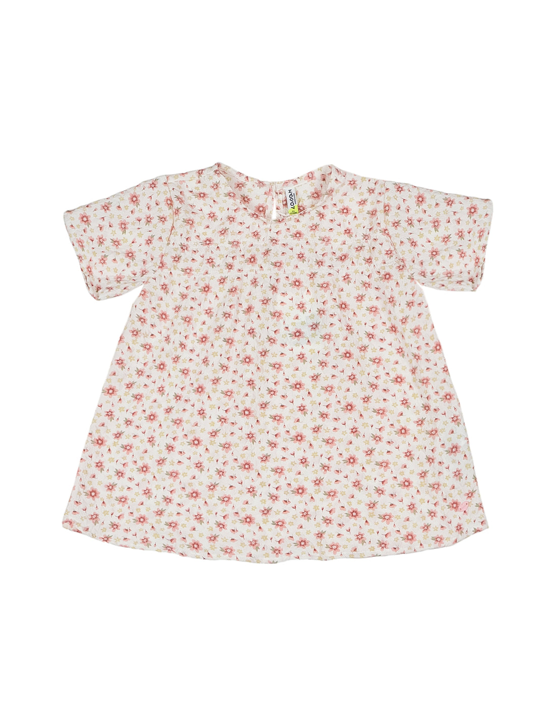 Blusa para niña color crudo con estampado floral pequeño y mangas cortas.
