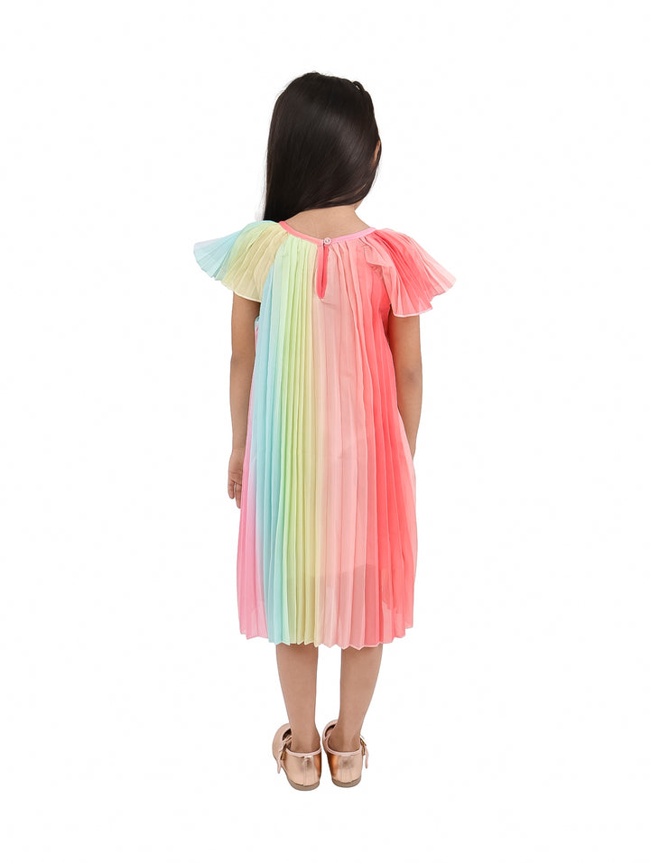 Niña vistiendo un vestido corto de tul plisado en colores arcoíris con predominancia del rosa.