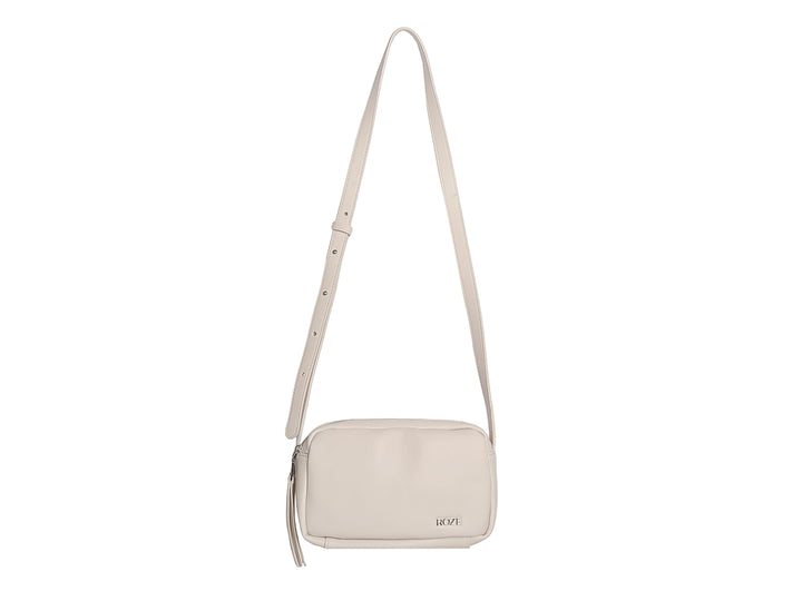 Bolsa de mano color beige marca ROZE con cierre y detalle de borla lateral.