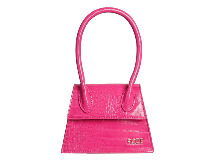 Bolso de mano pequeño color rosa fucsia con textura de piel de cocodrilo y asa circular.