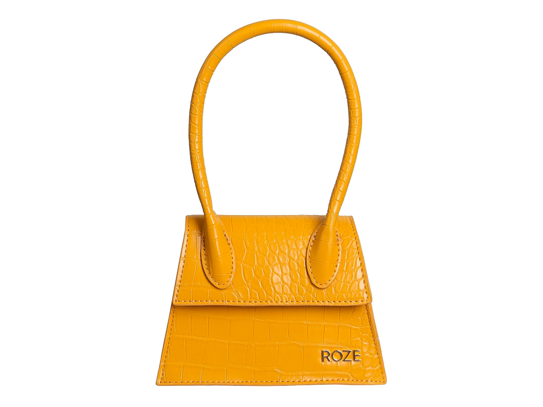 Bolso amarillo ROZE con textura de piel de cocodrilo y asa circular.