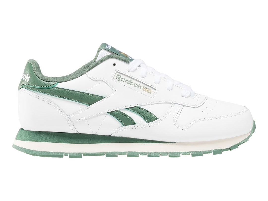 Tenis Reebok Classic Leather blancos con detalles y suela en color verde.