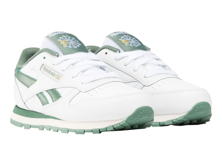 Tenis Reebok Classic Leather blancos con detalles y suela en color verde.