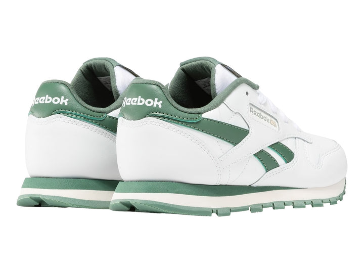 Tenis Reebok Classic Leather blancos con detalles y suela en color verde.