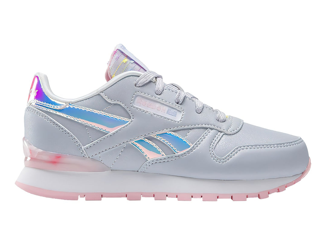 Tenis Reebok Classic Leather en color gris con detalles iridiscentes y suela rosa para niña.