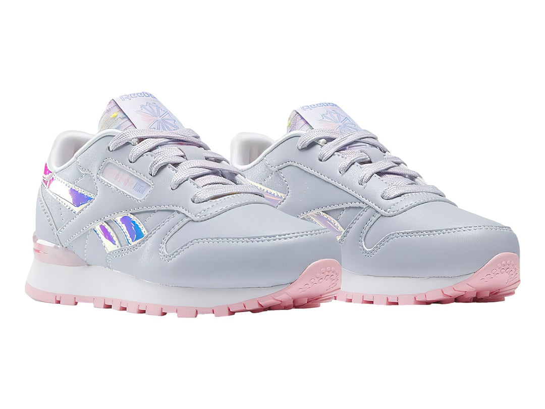 Tenis Reebok Classic Leather en color gris con detalles iridiscentes y suela rosa para niña.