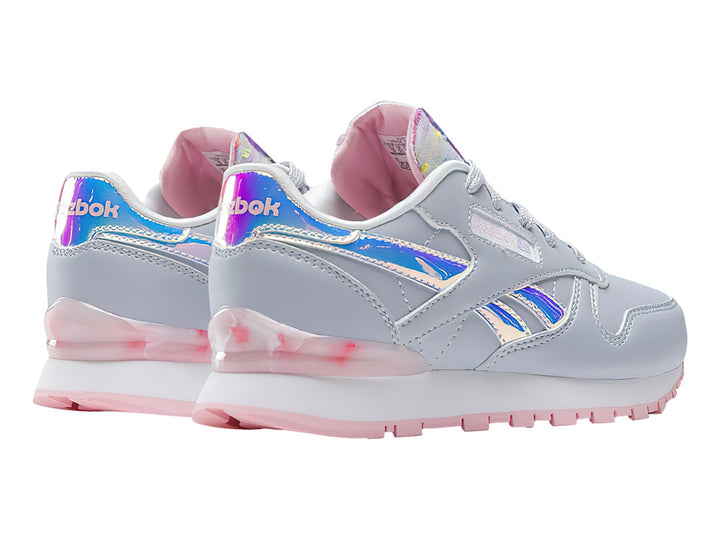 Tenis Reebok Classic Leather en color gris con detalles iridiscentes y suela rosa para niña.