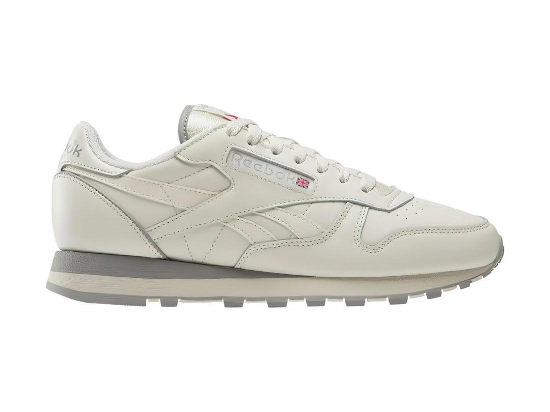 Tenis Reebok Classic Leather en color blanco hueso con suela gris, vista lateral.