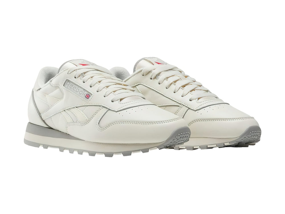Tenis Reebok Classic Leather en color blanco hueso con suela gris, vista lateral.