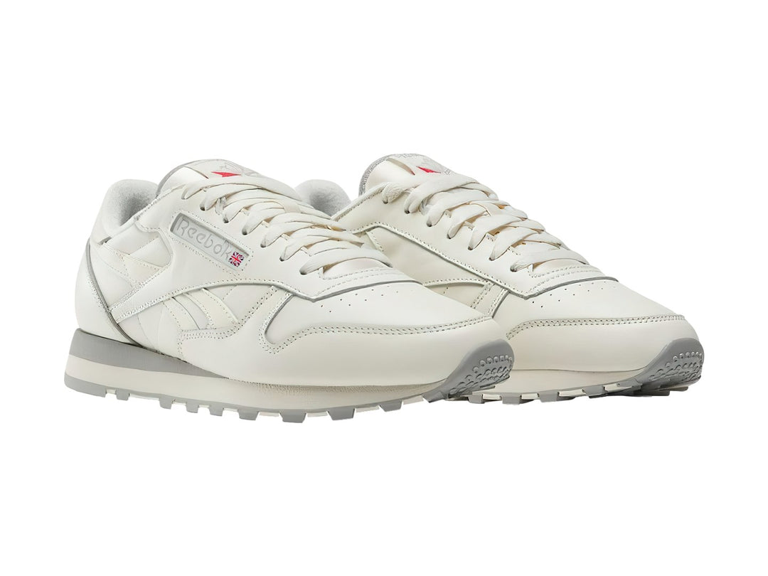 Tenis Reebok Classic Leather en color blanco hueso con suela gris, vista lateral.