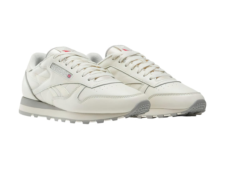 Tenis Reebok Classic Leather en color blanco hueso con suela gris, vista lateral.
