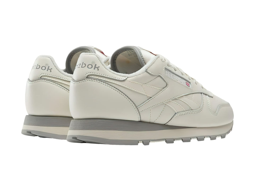 Tenis Reebok Classic Leather en color blanco hueso con suela gris, vista lateral.