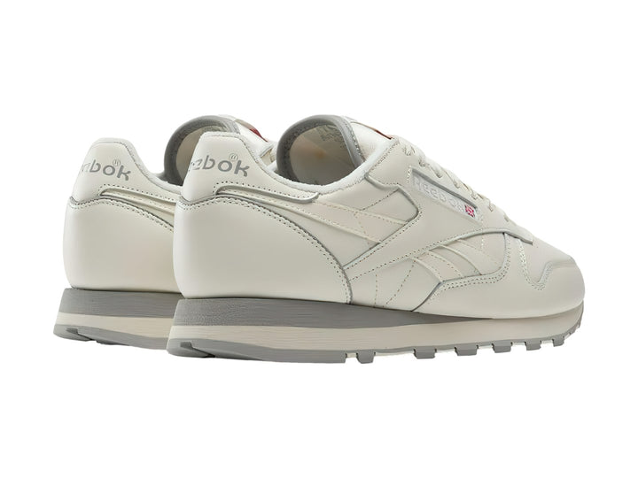Tenis Reebok Classic Leather en color blanco hueso con suela gris, vista lateral.