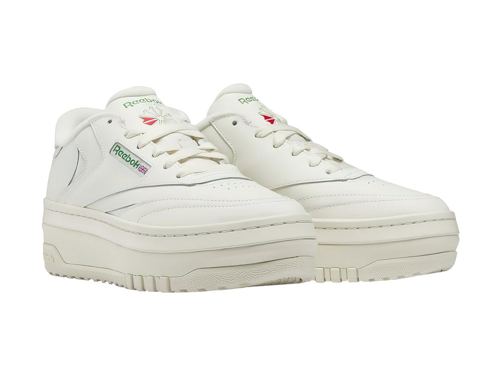 Tenis blancos Reebok Club C Extra con suela de plataforma y detalles en color verde.