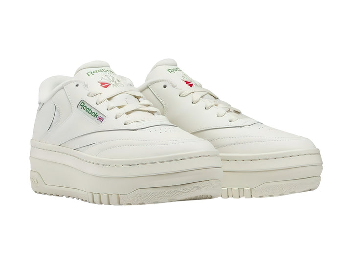 Tenis blancos Reebok Club C Extra con suela de plataforma y detalles en color verde.