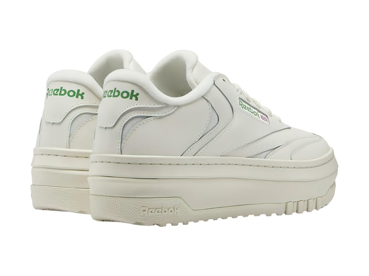 Tenis blancos Reebok Club C Extra con suela de plataforma y detalles en color verde.