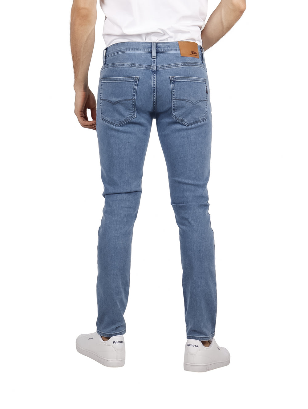 Hombre vistiendo pantalones jeans de color azul claro con corte ajustado.