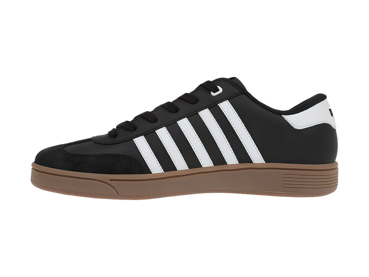 Tenis K-Swiss negros con franjas blancas laterales y suela color café.